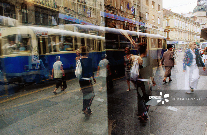 伊利卡大街的商店橱窗中反射的行人和有轨电车图片素材