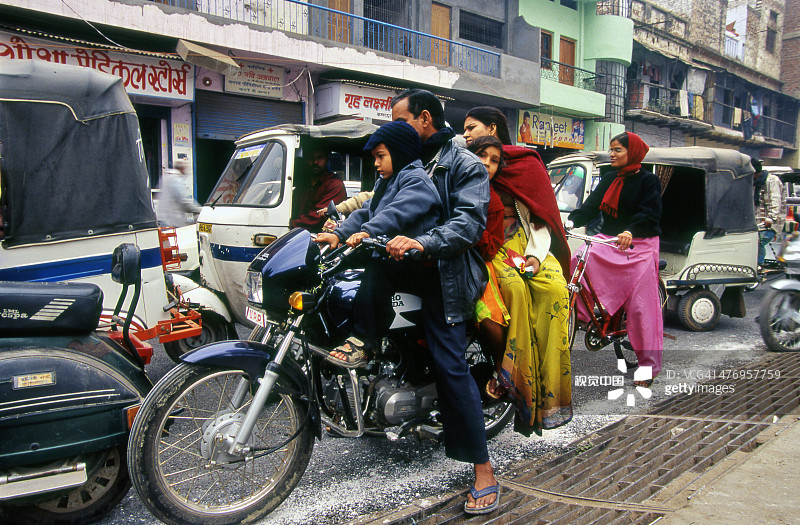 瓦拉纳西骑摩托车的四口彩色家庭图片素材
