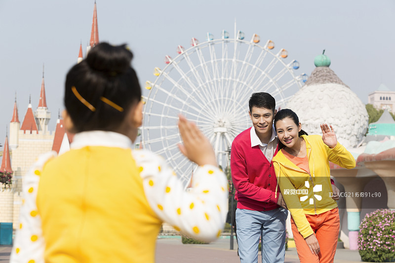 快乐的一家三口去游乐园玩图片素材