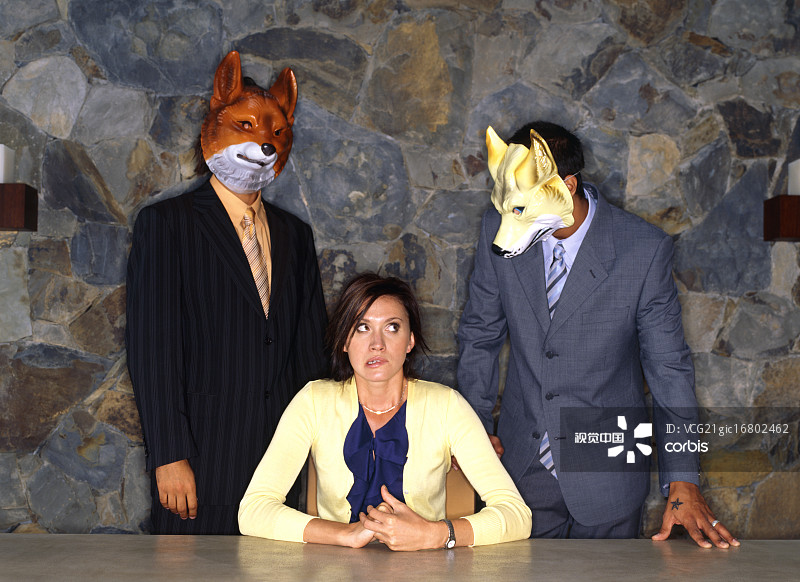 戴面具的两名男子站在坐在桌旁的女子身后图片素材