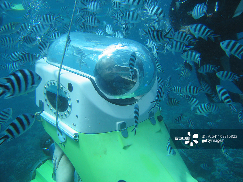 蓝色海底世界水下三米处的潜水艇和鱼群图片素材