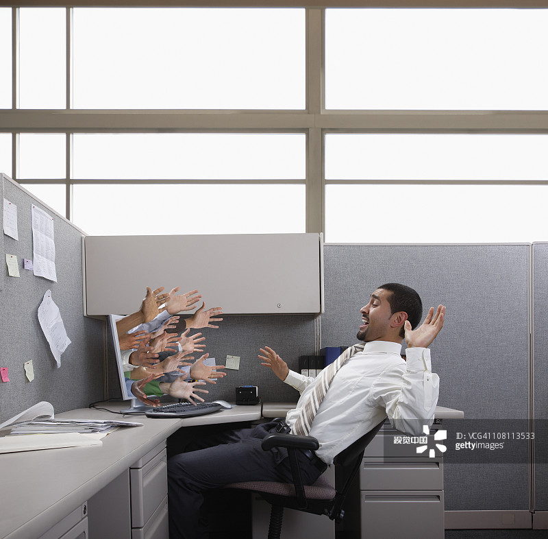 手从电脑中伸出，试图抓住西班牙裔商人图片素材