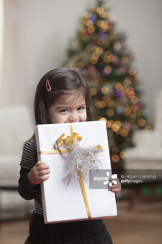 手拿圣诞礼物的西班牙裔女孩图片素材