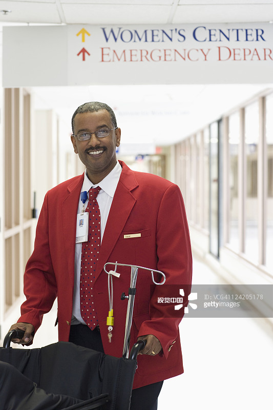 在走廊里推轮椅的非裔美国医院工作人员图片素材