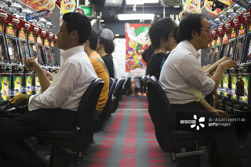 在日本东京的游乐厅里享受弹珠游戏的玩家图片素材
