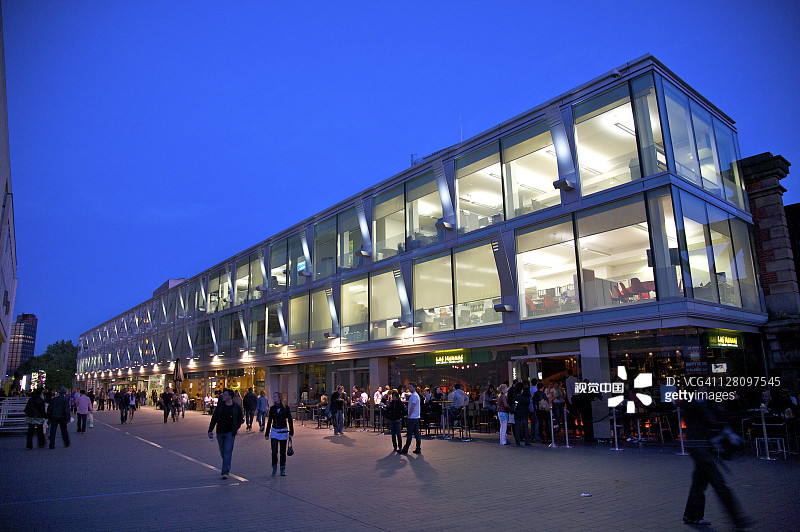 在伦敦泰晤士河畔 Jubilee Walk 皇家国家剧院旁的咖啡馆里的人们图片素材