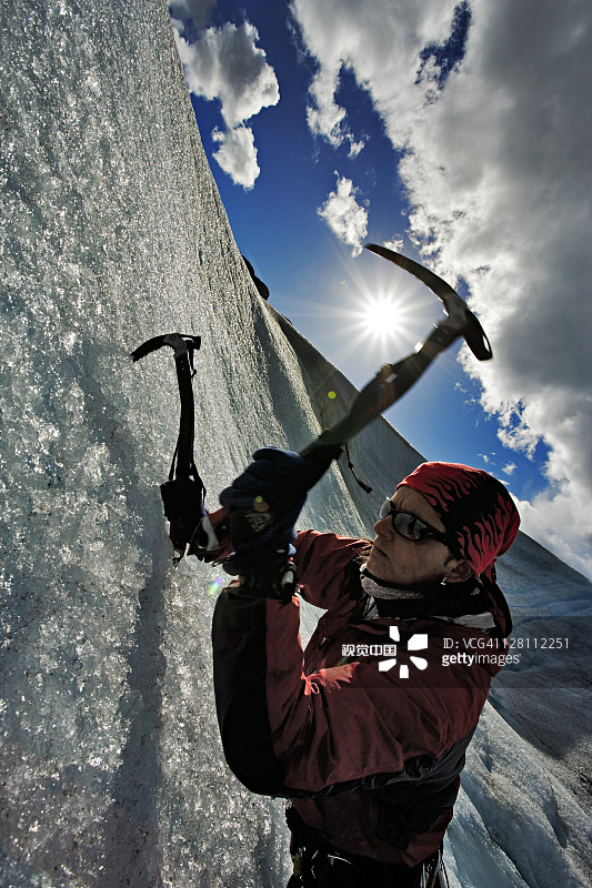 男人借助冰镐攀登壮丽冰川裂缝，格雷冰川，百内国家公园，智利图片素材