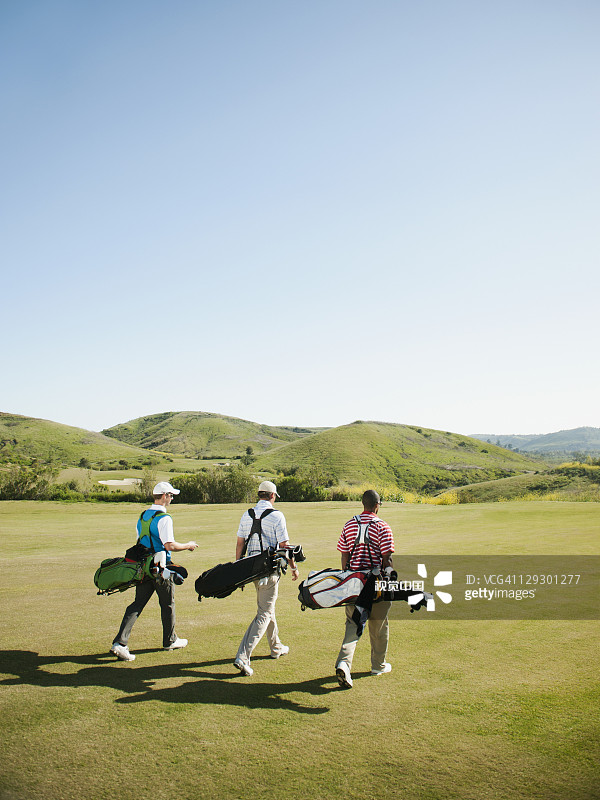 男人在高尔夫球场上携带高尔夫球包图片素材