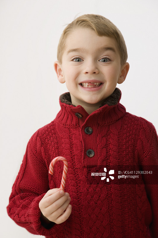 吃着圣诞节糖果的白人男孩图片素材