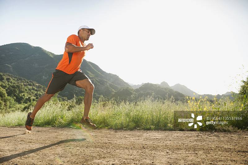 混血男士在偏僻小路上跑步图片素材