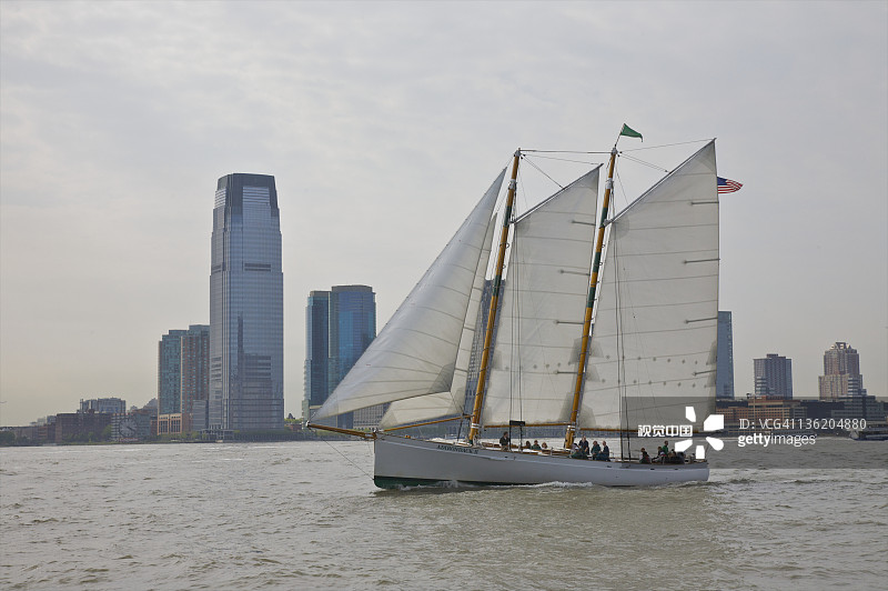 办公楼附近水面上的双桅帆船图片素材