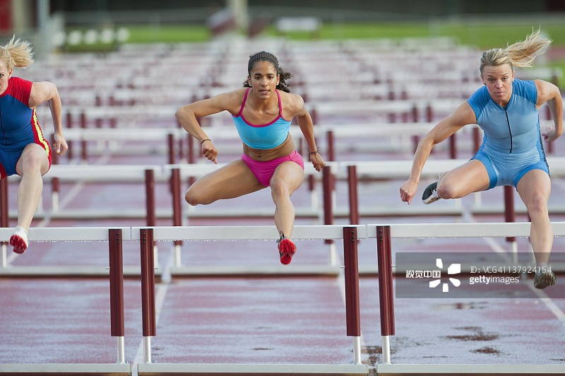 赛跑中跨越障碍的跑步者图片素材