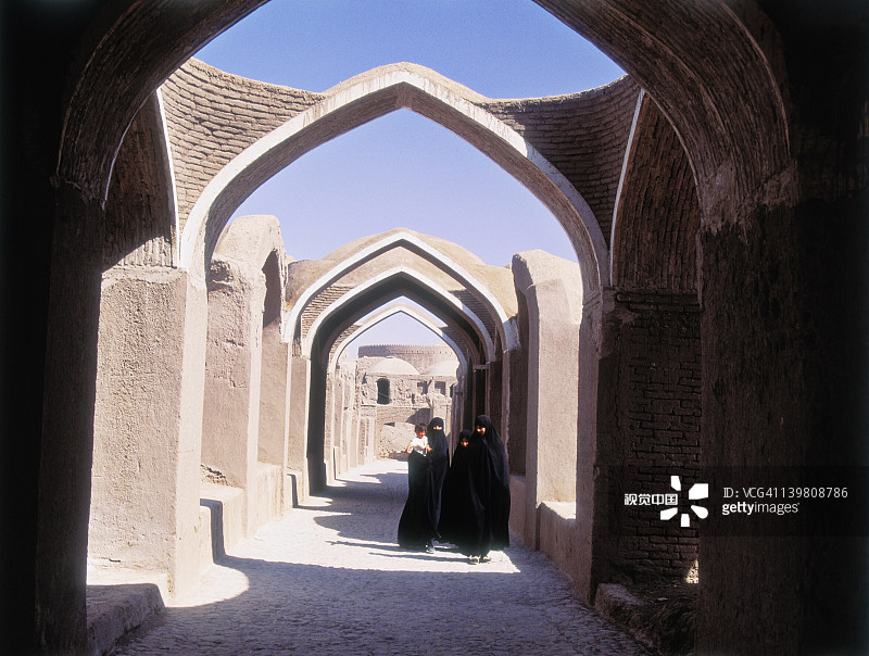 在伊朗巴姆古城堡拱门街道上的女人图片素材