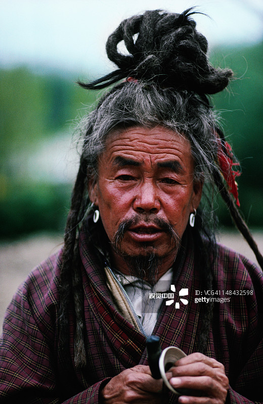 廷布周日市场上一位宗教人士转动祈祷轮图片素材