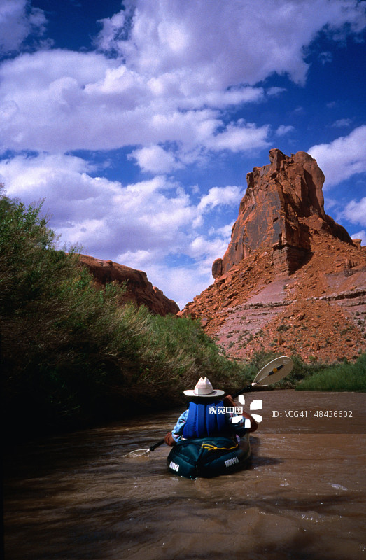 男人划皮划艇驶向岩层图片素材