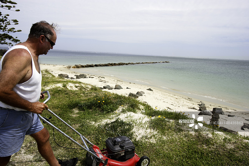 男人在植物湾银滩修剪草坪图片素材
