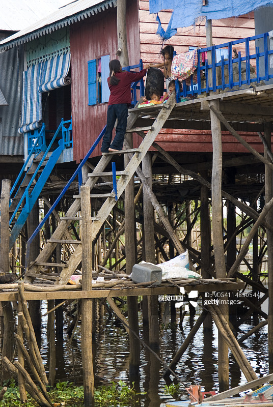 在洞里萨湖水上村庄高跷房屋外面的家庭图片素材
