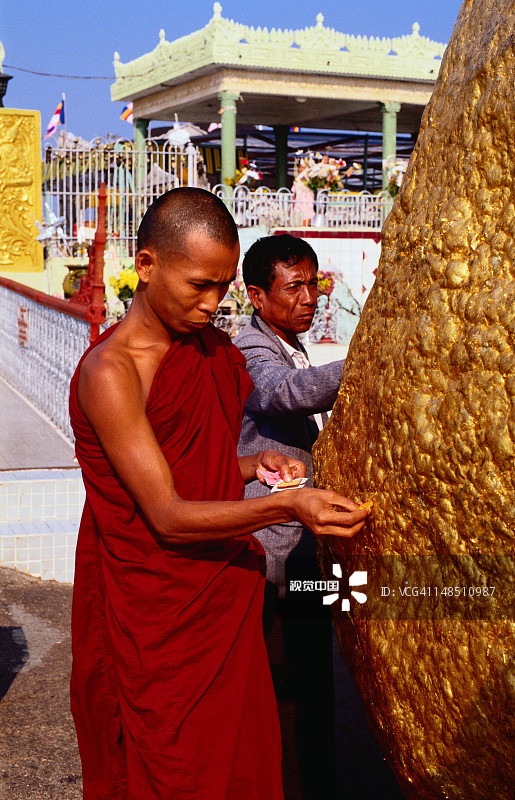 僧侣在孟邦吉谛瑜大金石宝塔上贴金箔图片素材
