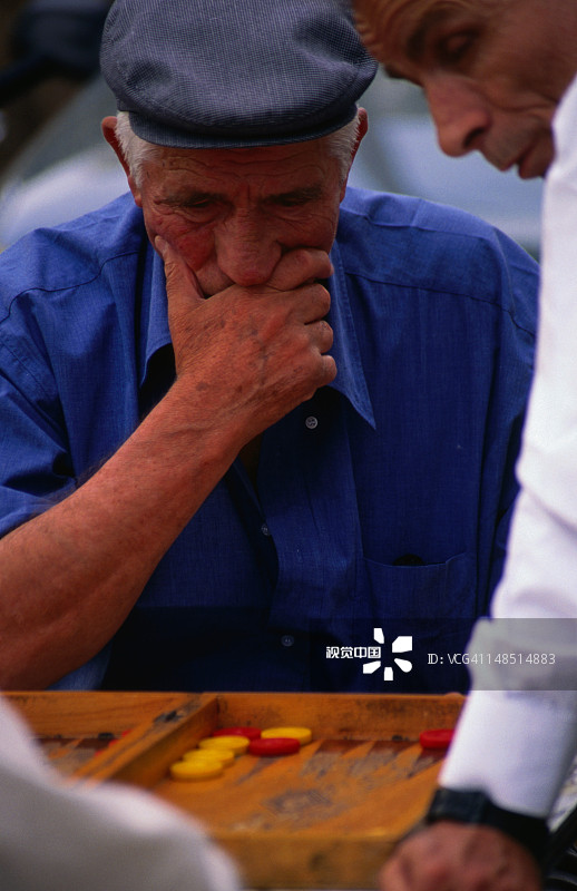当地男人专注于西洋双陆棋的下一步图片素材