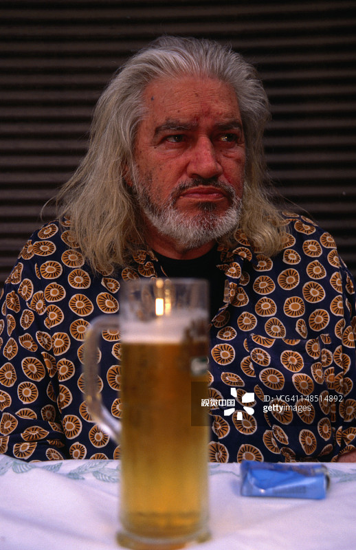 坐在啤酒杯后的男人图片素材