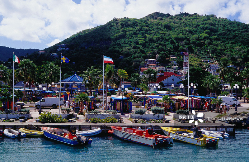 停靠在公共市场手工艺品摊位附近水边的船只图片素材