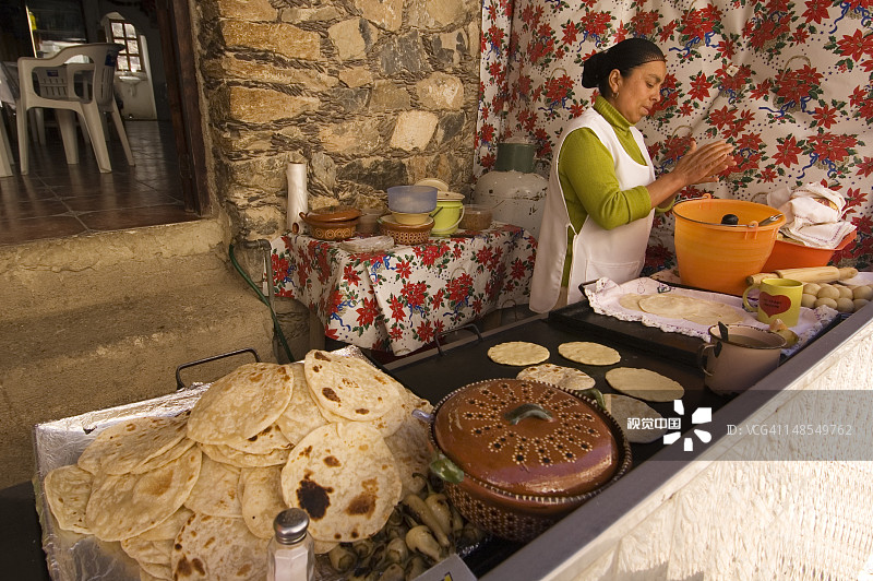 女人在Catorce市场制作玉米饼图片素材