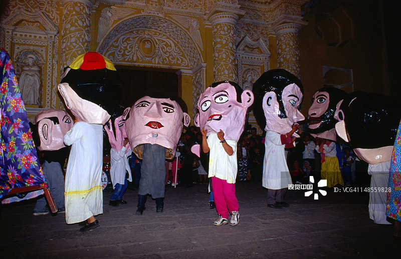 新年庆祝活动中在梅赛德教堂外表演巨人舞的戴面具的人们图片素材