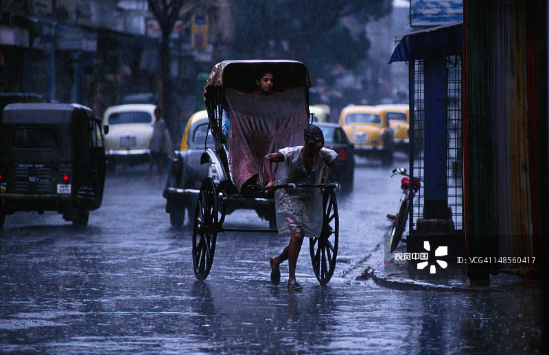 季风季加尔各答：浸水的黄包车夫安全送乘客回家图片素材