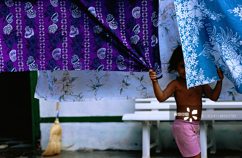 在晾晒衣物后面的害羞女孩图片素材