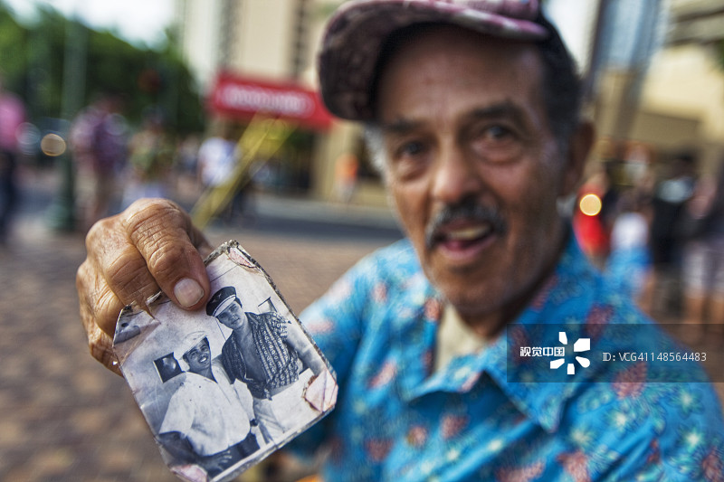 男人自豪地展示自己与埃尔维斯·普雷斯利在怀基基大道上的旧照片图片素材