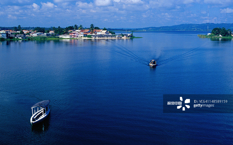 在佩滕伊察湖上巡游的船只，背景是弗洛雷斯镇，该镇建在湖中的一个岛屿上图片素材