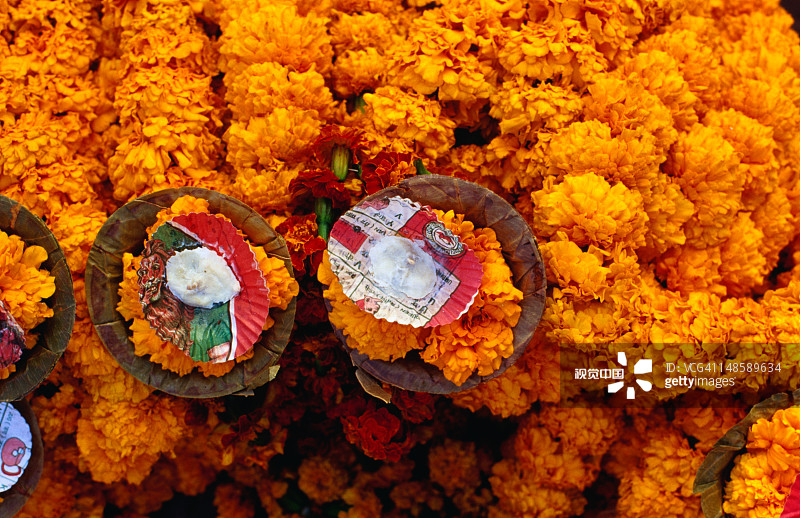 Dasaswamedh Ghat出售的用于宗教祭祀的万寿菊花环和蜡烛图片素材