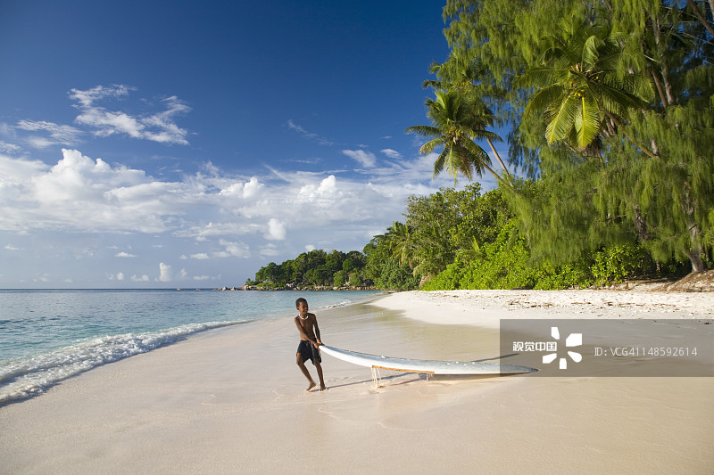 当地男孩在Anse Severe将冲浪板拉到水边图片素材