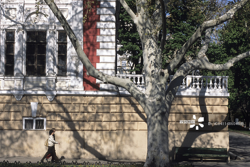 旧建筑前行走的女士图片素材
