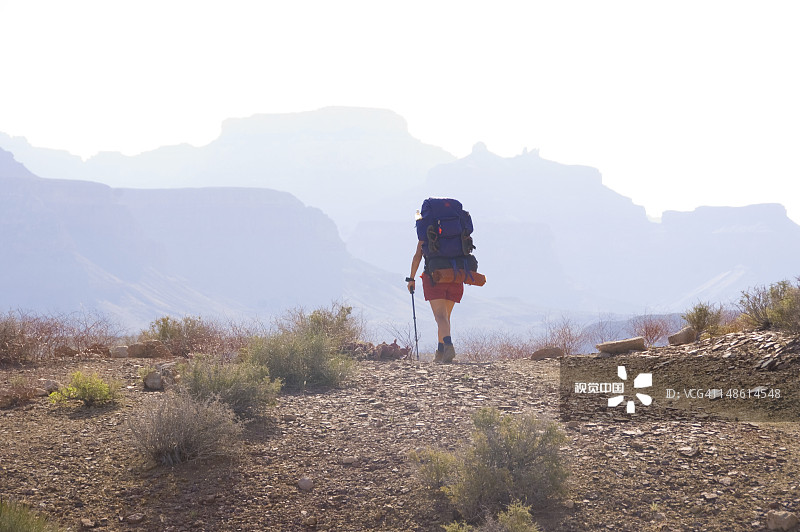 在通托小道上使用登山杖的女背包客图片素材
