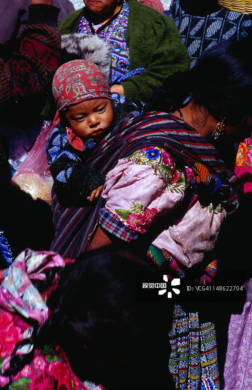 人群中，妈妈背上的宝宝图片素材