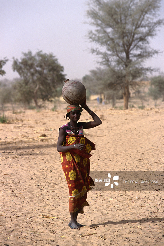 一位当地妇女从井里取水归来图片素材