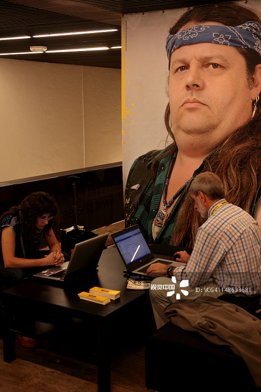 在马德里城市文化中心哥伦布广场的哥伦布纪念碑下使用无线网络的游客图片素材