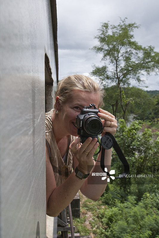 在北碧府桂河死亡铁路的观光列车上，女人正在拍照图片素材