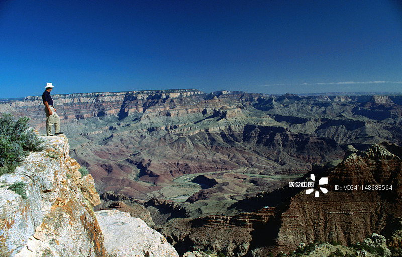 一名戴帽子的男子站在利潘角，俯瞰大峡谷——亚利桑那州大峡谷国家公园图片素材