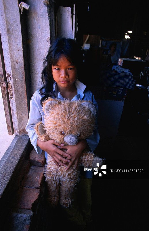 金边孤儿院的女孩和她的泰迪熊图片素材