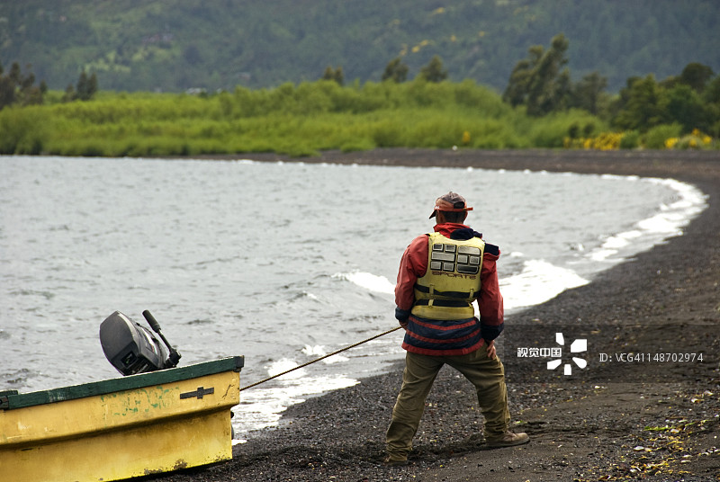 男人在比亚里卡湖拉船上岸。图片素材
