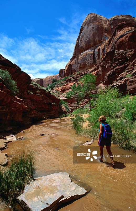 一名女子在犹他州格伦峡谷国家游乐区浅水中行走图片素材