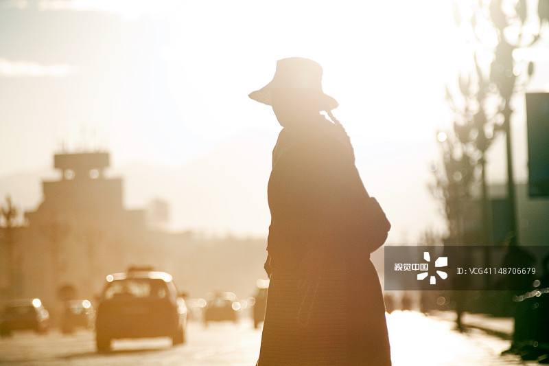 清晨，在北京中路布达拉宫对面过马路的女人图片素材