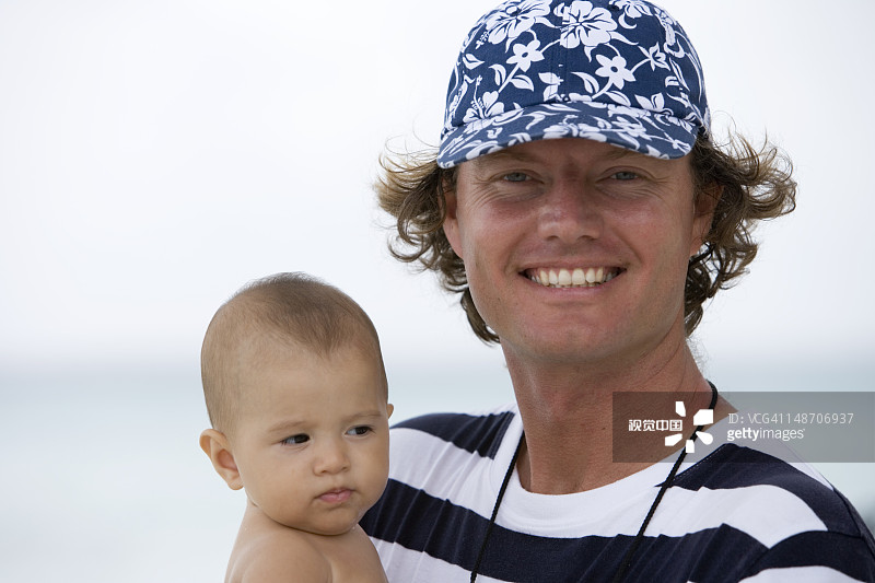 男人抱着年轻的波利尼西亚男孩图片素材