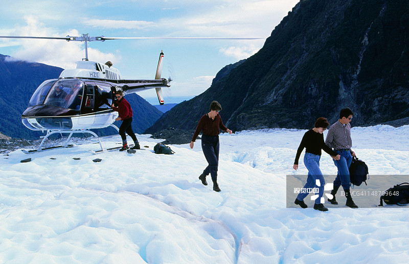 步行者离开冰川上的直升机图片素材