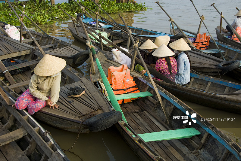 在湄公河三角洲等候出租船搭载乘客的妇女图片素材