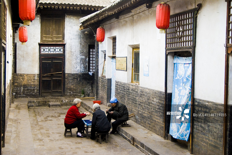 当村房屋内庭院里的妇女图片素材