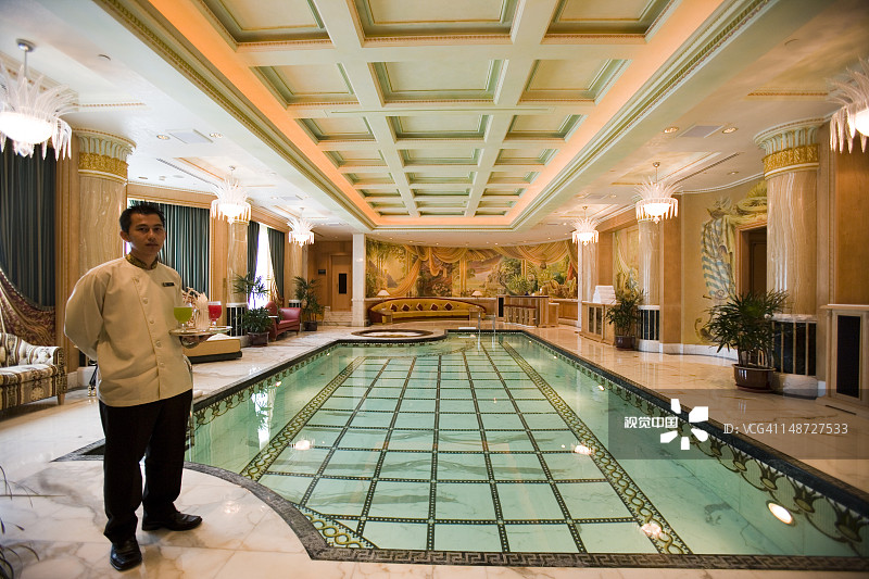 在文莱达鲁萨兰帝国酒店和乡村俱乐部的泳池边的管家图片素材