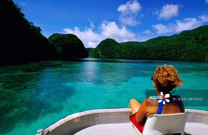 女人乘船在热带泻湖上巡游图片素材